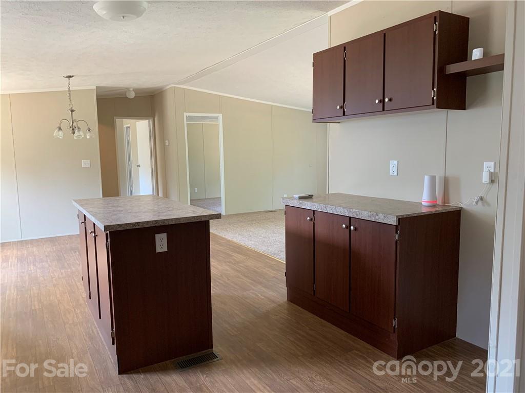 169 Mosley Road Blacksburg, SC 29702 - Photo 9 of 20 a kitchen with granite countertop a refrigerator a stove and wooden cabinets