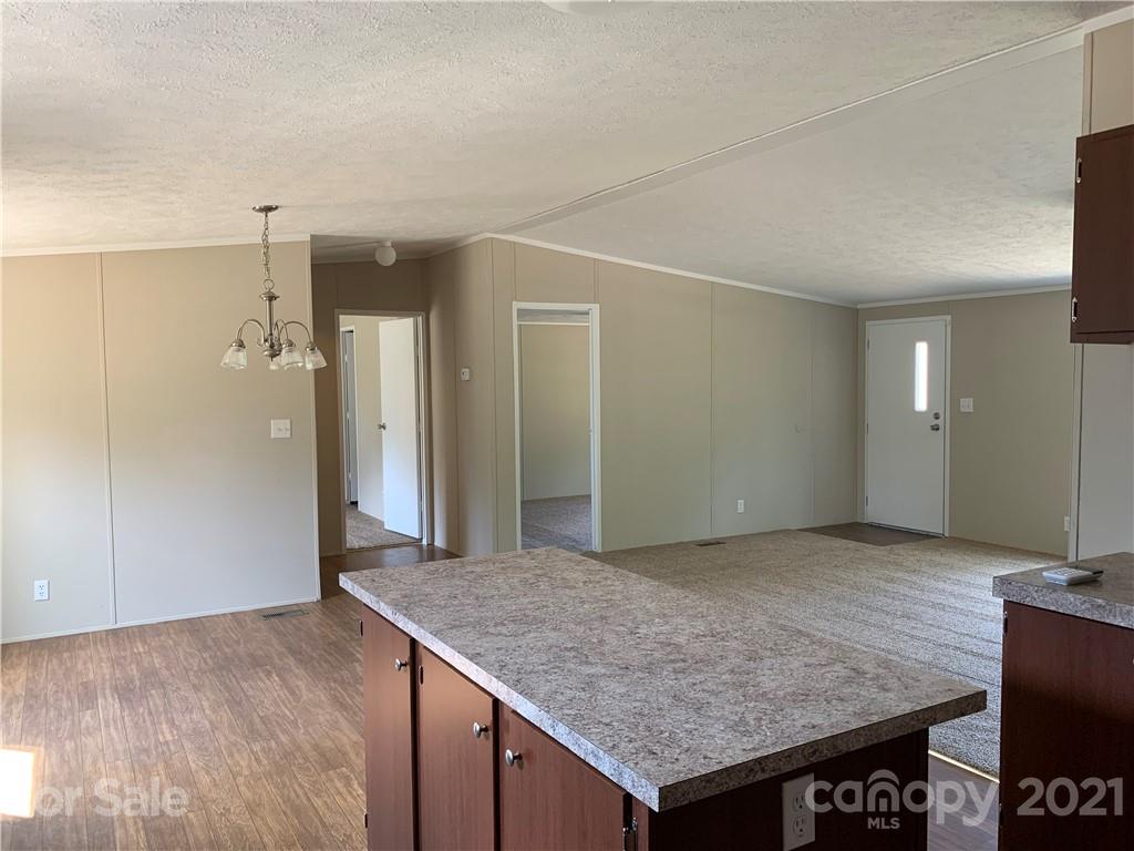 169 Mosley Road Blacksburg, SC 29702 - Photo 10 of 20 an empty room with kitchen view and wooden floor
