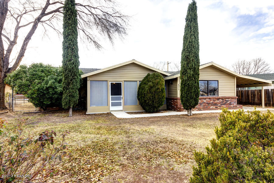 8049 East Barbara Road Prescott Valley, AZ 86314 - Photo 1 of 23 a front view of a house with a yard and garage