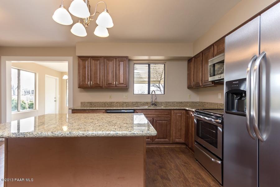 8049 East Barbara Road Prescott Valley, AZ 86314 - Photo 12 of 23 a kitchen with stainless steel appliances granite countertop a sink a stove cabinets counter space and a window