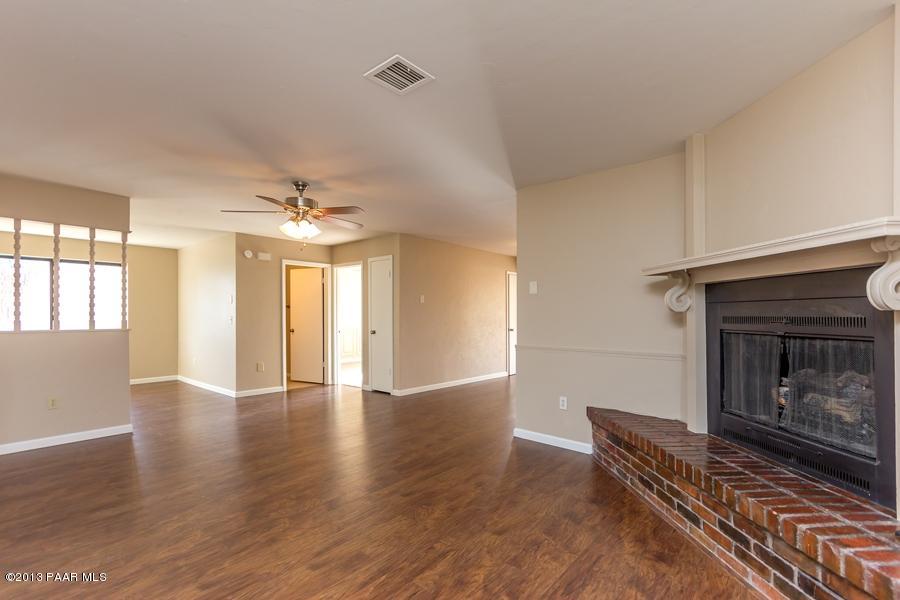 8049 East Barbara Road Prescott Valley, AZ 86314 - Photo 7 of 23 a view of an empty room with wooden floor fireplace and a window