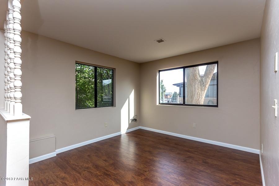 8049 East Barbara Road Prescott Valley, AZ 86314 - Photo 9 of 23 an empty room with wooden floor and windows
