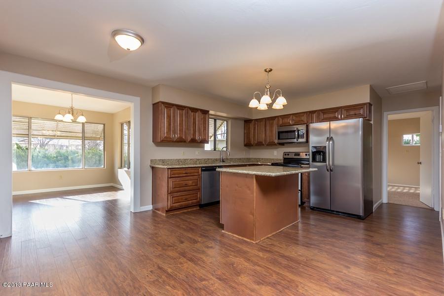 8049 East Barbara Road Prescott Valley, AZ 86314 - Photo 10 of 23 a large kitchen with kitchen island a sink and a refrigerator