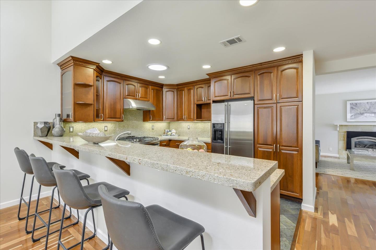828 Linda Mar Boulevard Pacifica, CA 94044 - Photo 14 of 44 a kitchen with granite countertop a refrigerator a stove a sink a dining table and chairs with wooden floor