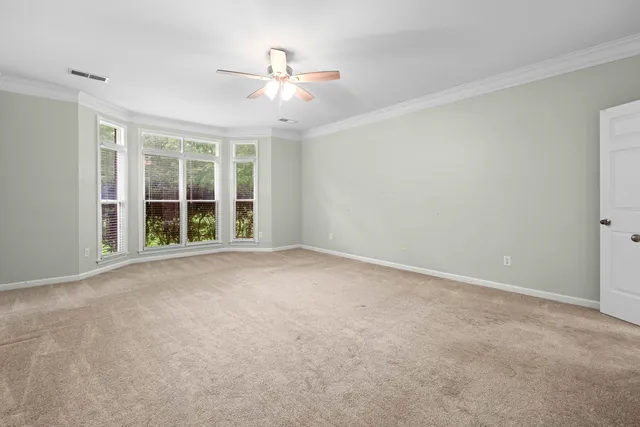 a spacious bedroom with a bed a couch and dresser