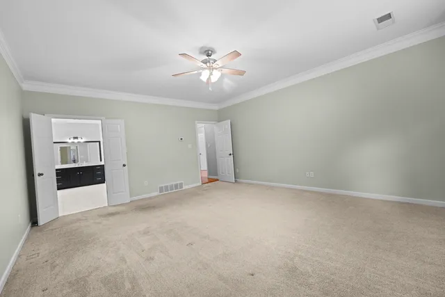 a view of an empty room with a chandelier fan
