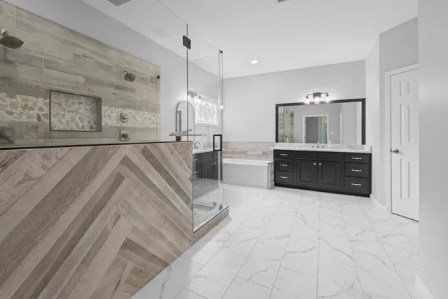 a spacious bathroom with a granite countertop double vanity sink and a mirror