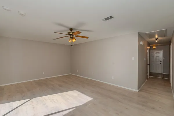 an empty room with a ceiling fan and hardwood floor