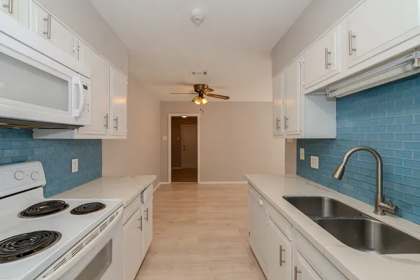 a kitchen with a white cabinets and stove top oven