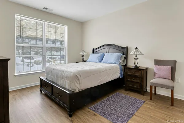 a large bedroom with a bed and wooden floor
