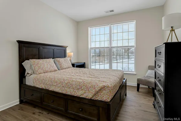 a bedroom with a bed and two windows