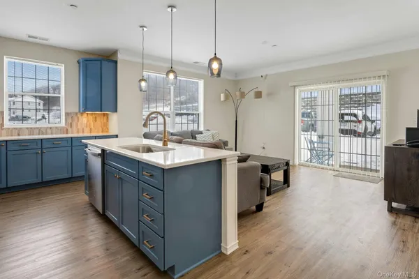 a kitchen with kitchen island granite countertop a sink counter space and wooden floor