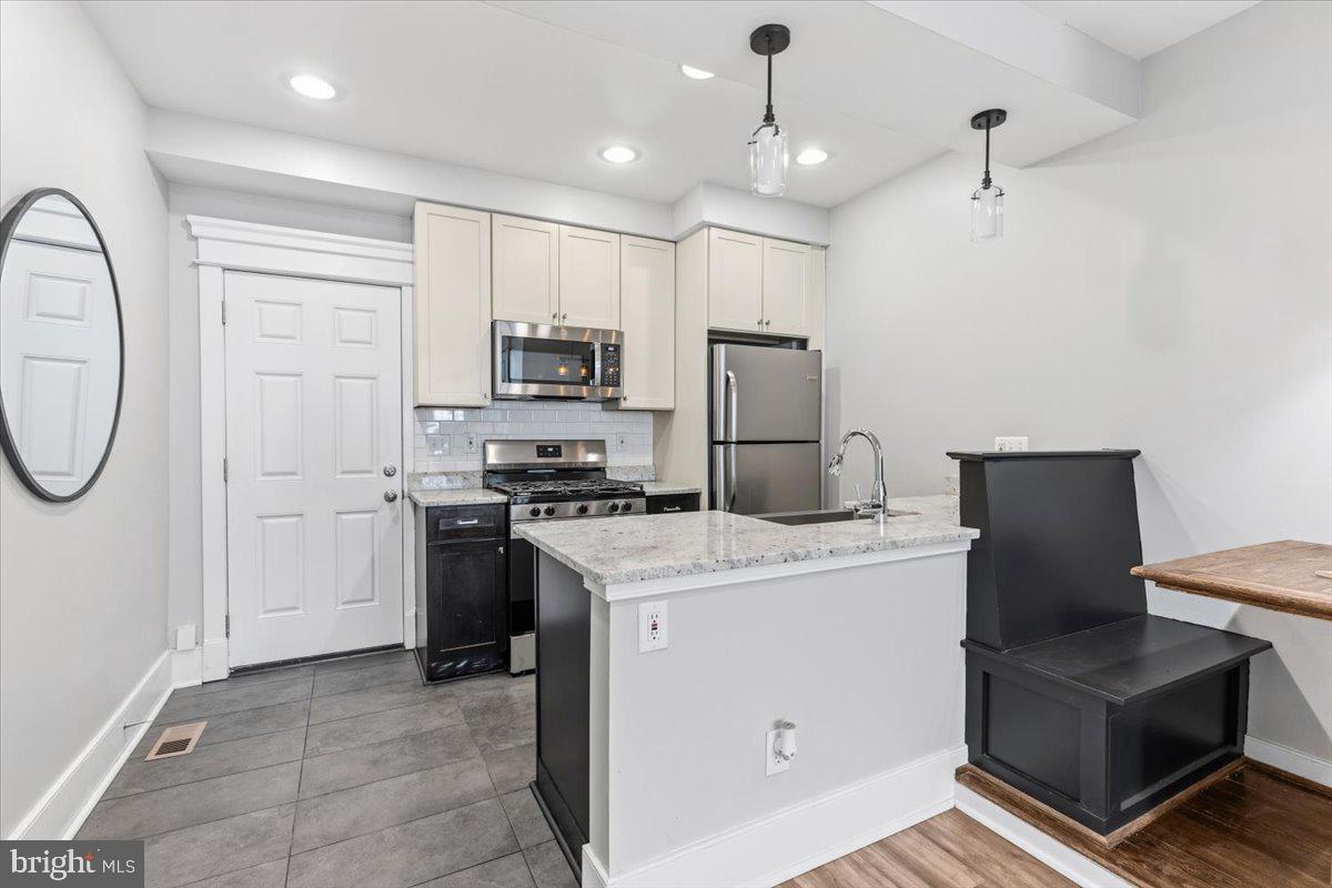 635 20th Street Northeast Washington, DC 20002 - Photo 11 of 33 a kitchen with kitchen island a stove a sink and a refrigerator