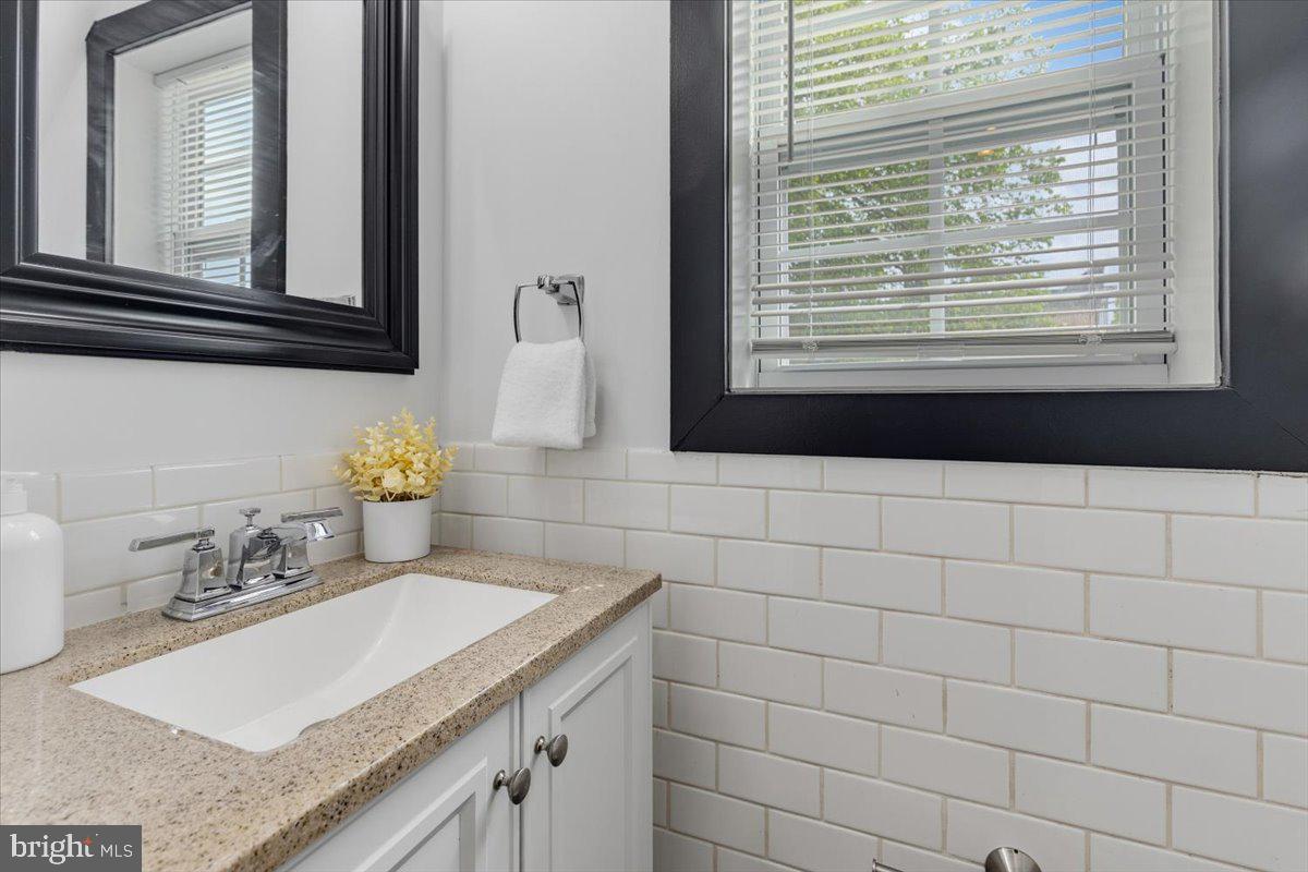 635 20th Street Northeast Washington, DC 20002 - Photo 13 of 32 a bathroom with a granite countertop sink and a mirror