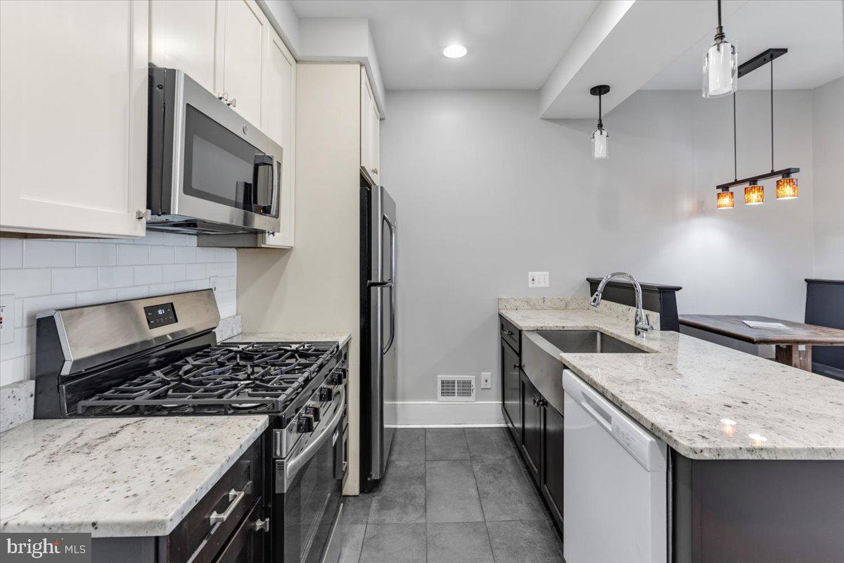 635 20th Street Northeast Washington, DC 20002 - Photo 13 of 33 a kitchen with stainless steel appliances granite countertop a sink stove and refrigerator