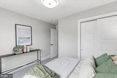 a bedroom with a bed and a mirror on the dresser