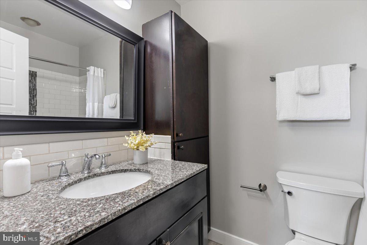 635 20th Street Northeast Washington, DC 20002 - Photo 23 of 33 a bathroom with a granite countertop sink and a mirror