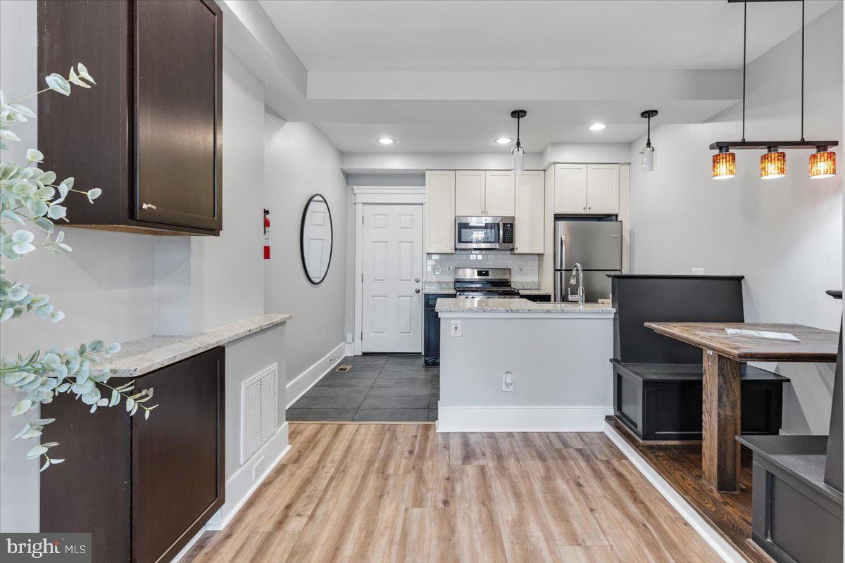 635 20th Street Northeast Washington, DC 20002 - Photo 8 of 33 a kitchen with kitchen island white cabinets and stainless steel appliances