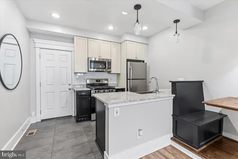 a kitchen with kitchen island a stove a sink and a refrigerator