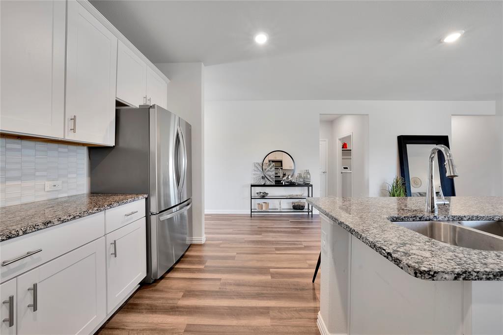 1817 Berry Rdg Trail Aubrey, TX 76227 - Photo 12 of 30 a kitchen with stainless steel appliances granite countertop a sink and a refrigerator