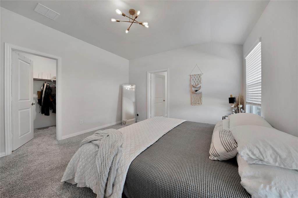 1817 Berry Rdg Trail Aubrey, TX 76227 - Photo 15 of 30 a bedroom with a bed and a chandelier