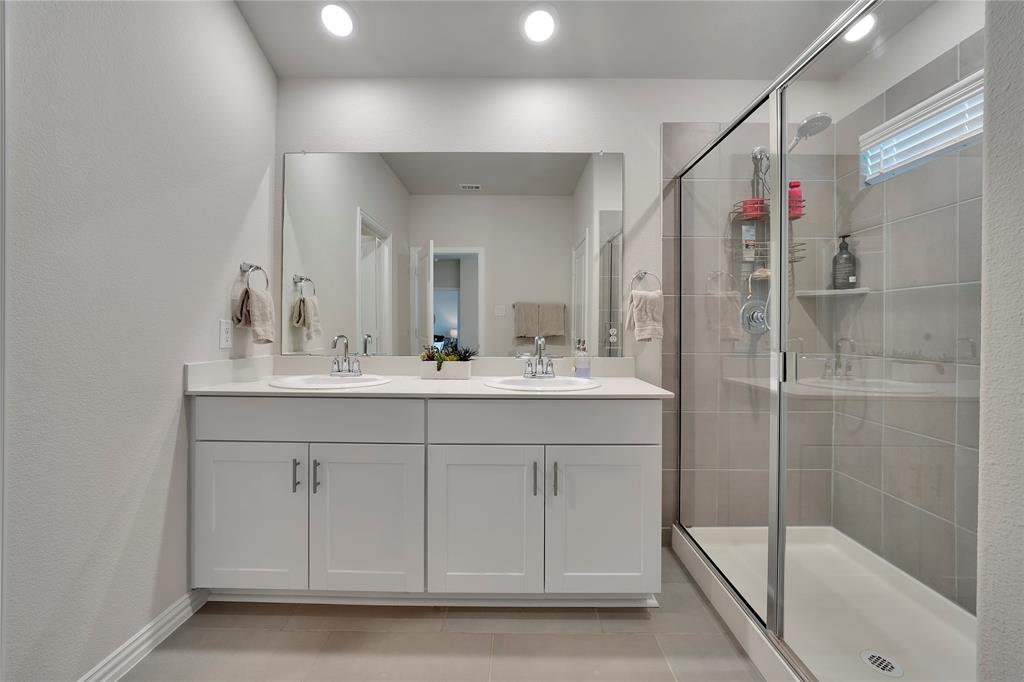 1817 Berry Rdg Trail Aubrey, TX 76227 - Photo 18 of 30 a bathroom with a shower sink vanity and mirror