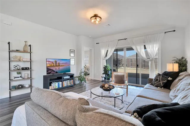 a living room with furniture a rug and a large window