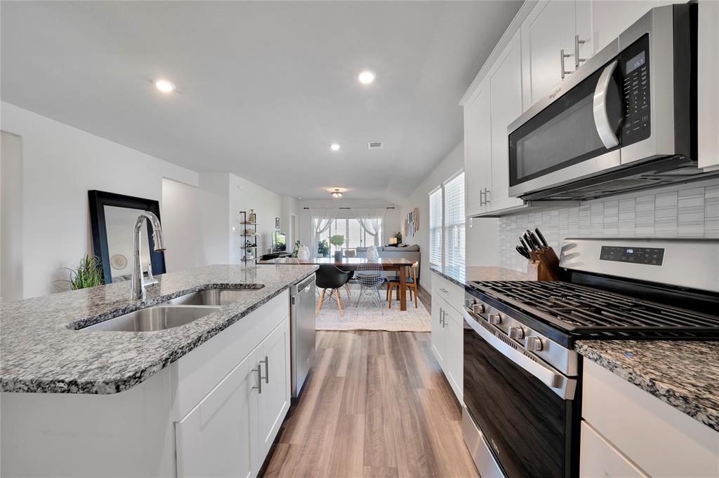 1817 Berry Rdg Trail Aubrey, TX 76227 - Photo 10 of 30 a kitchen with stainless steel appliances granite countertop a stove and a sink