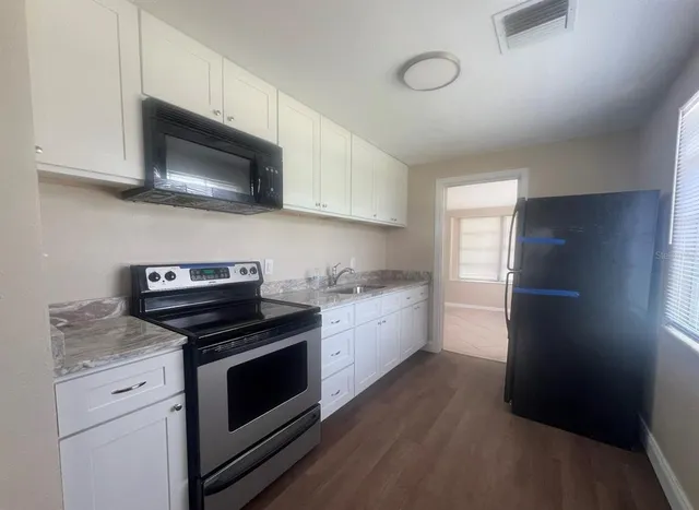 a kitchen with a stove microwave and sink