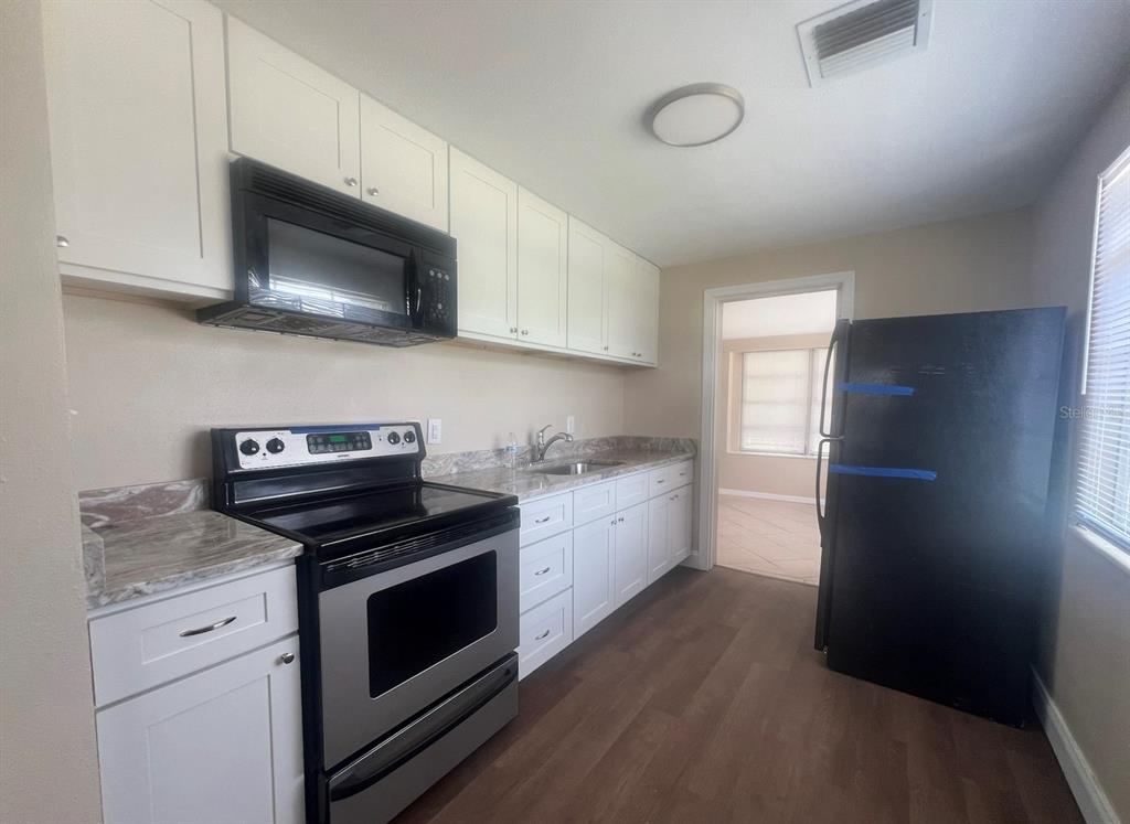 15 Haselton Street Eustis, FL 32726 - Photo 5 of 10 a kitchen with a stove microwave and sink