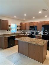 3826 Exeter Lane Lakeland, FL 33809 - Photo 2 of 10 a kitchen with stainless steel appliances granite countertop a stove a sink a refrigerator and a microwave
