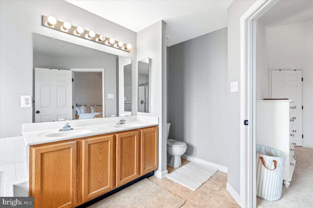 1729 Emory Street Frederick, MD 21701 - Photo 22 of 50 a spacious bathroom with a double vanity sink a toilet and a mirror
