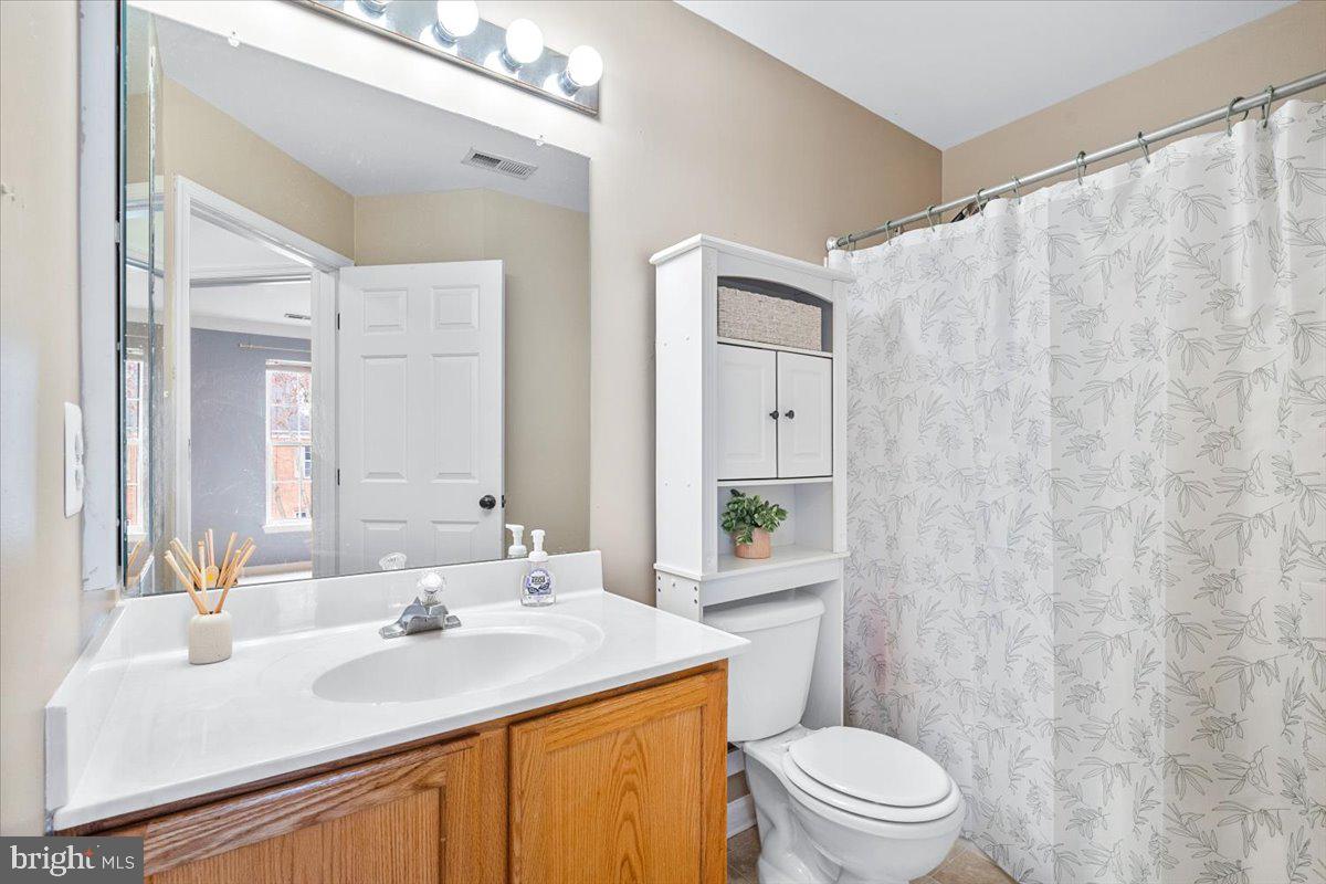 1729 Emory Street Frederick, MD 21701 - Photo 25 of 50 a bathroom with a sink toilet a mirror and shower curtain