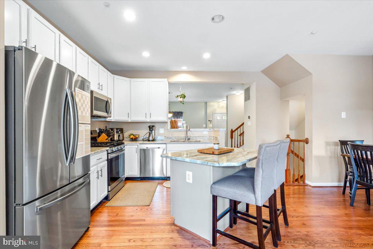 1729 Emory Street Frederick, MD 21701 - Photo 5 of 50 a kitchen with stainless steel appliances a dining table chairs refrigerator and microwave