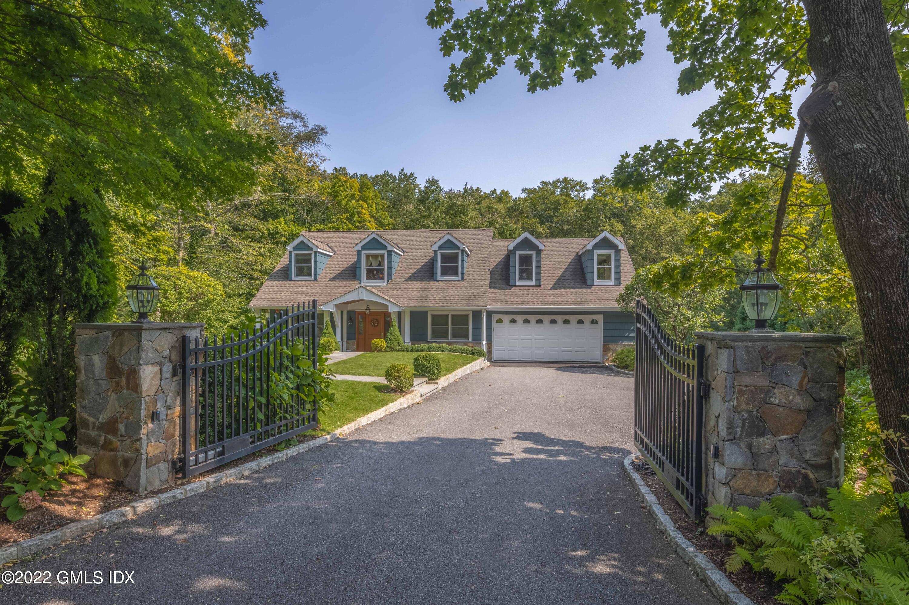 a view of a house with a small yard and a large tree