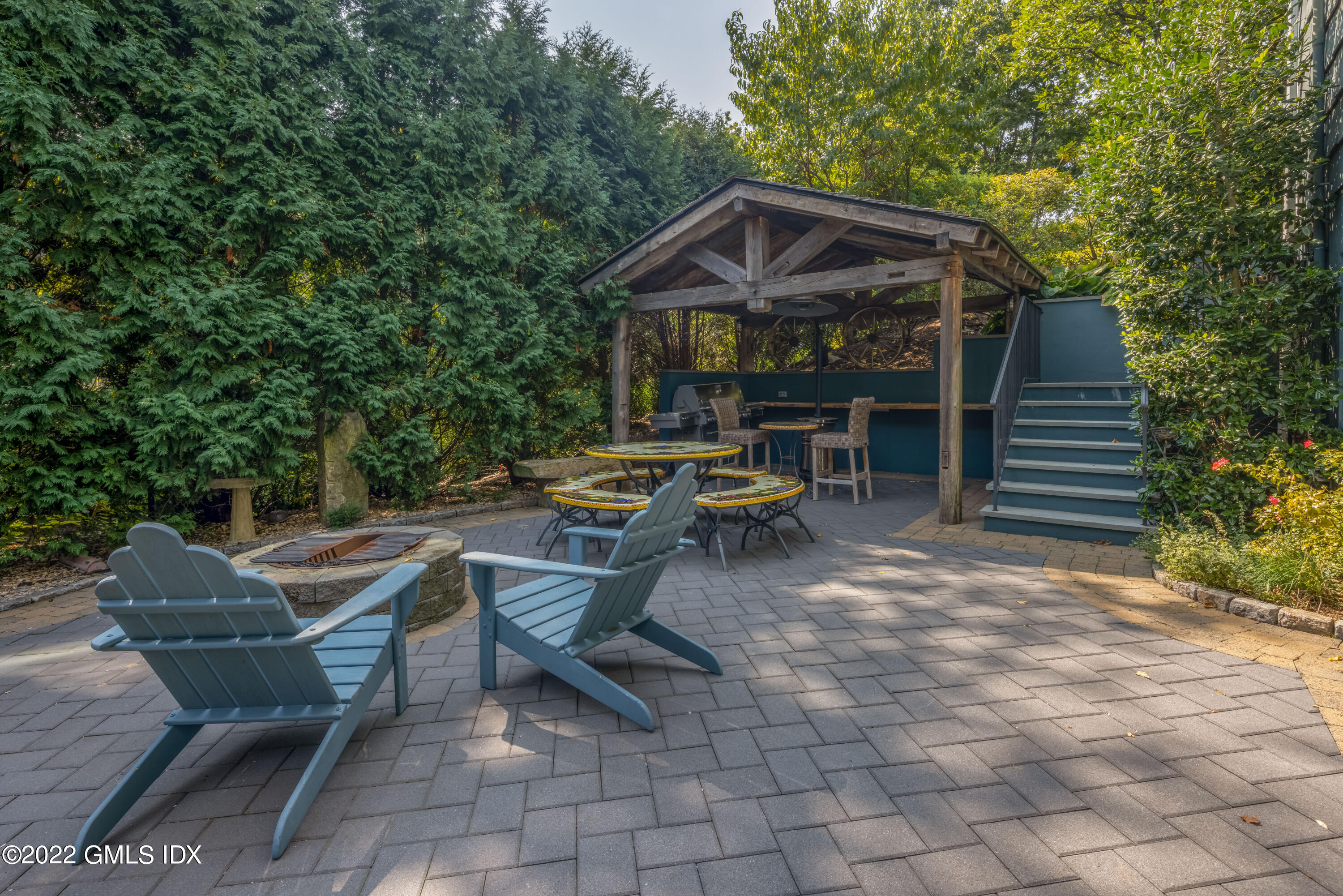 27 Rustic View Road Greenwich, CT 06830 - Photo 23 of 37 a view of a patio with table and chairs with wooden fence and plants