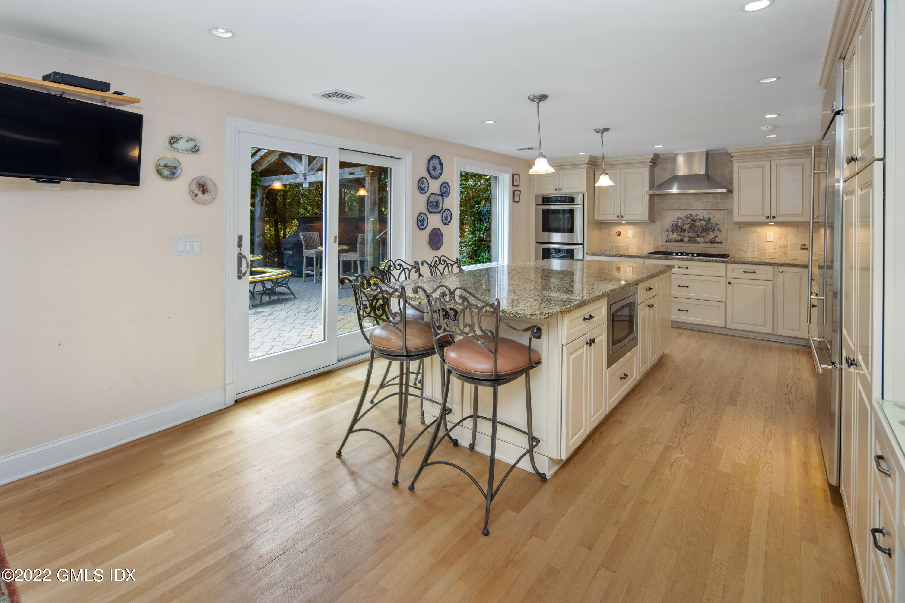 27 Rustic View Road Greenwich, CT 06830 - Photo 8 of 37 a kitchen with stainless steel appliances a dining table chairs stove and cabinets