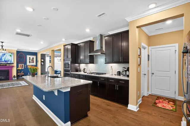 a large kitchen with stainless steel appliances granite countertop a lot of counter space and wooden floor