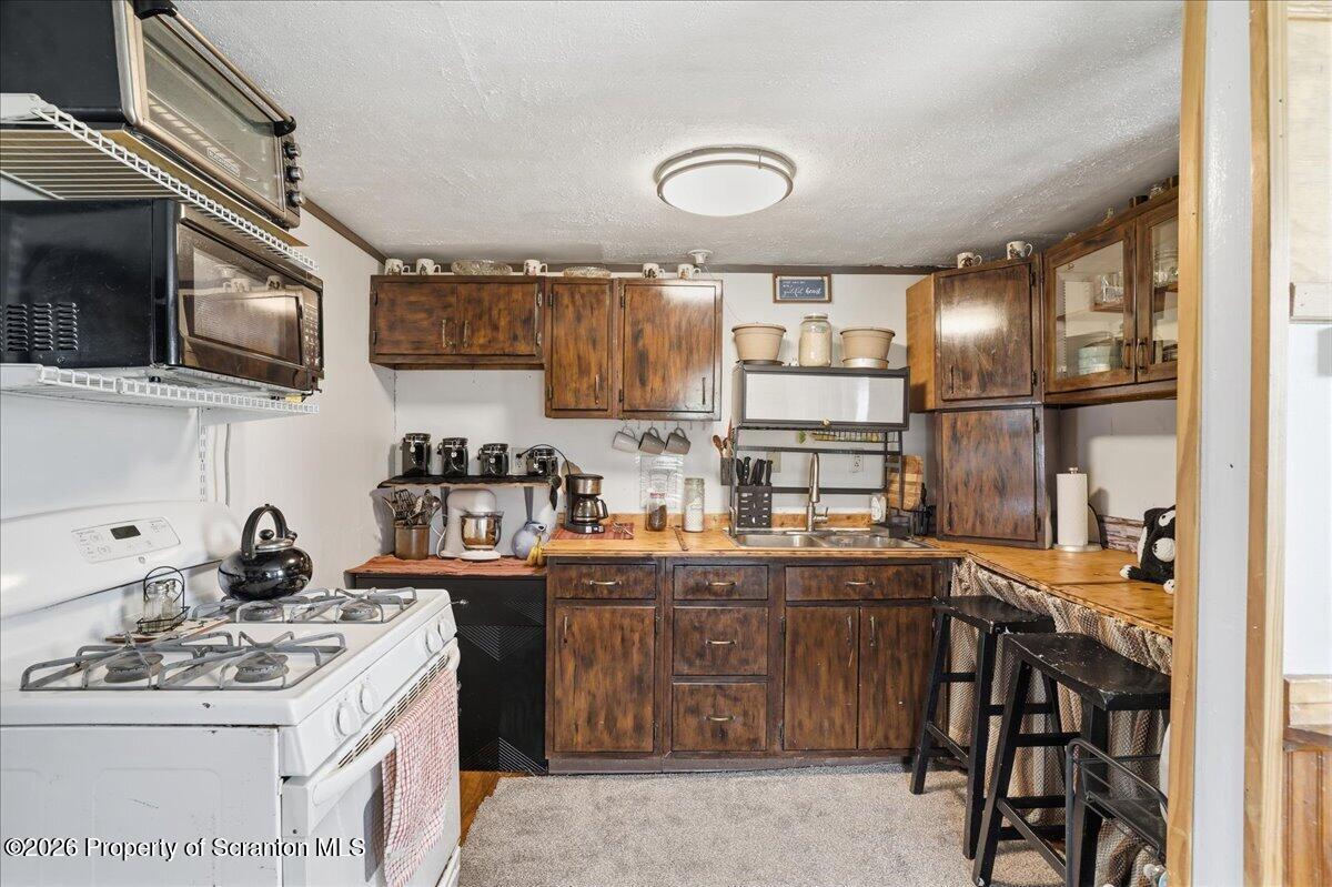 1140 Ball Pond Road Thompson, PA 18465 - Photo 57 of 68 a kitchen with a sink a stove and cabinets