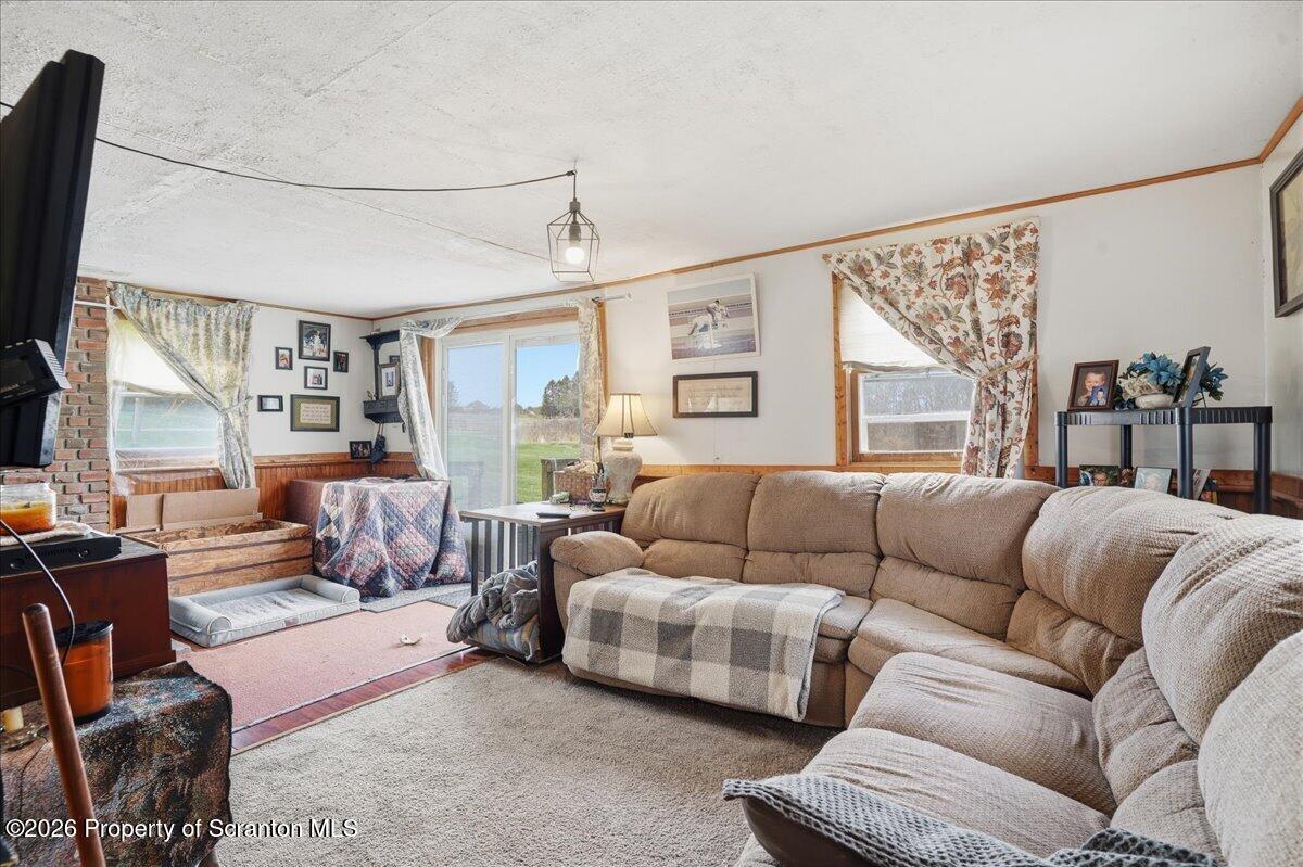 1140 Ball Pond Road Thompson, PA 18465 - Photo 63 of 68 a living room with furniture a large window and a flat screen tv