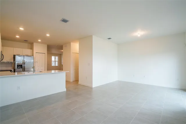a view of kitchen with kitchen island and stainless steel appliances