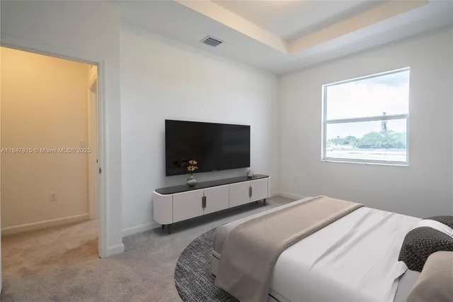 a bedroom with a bed and a flat screen tv