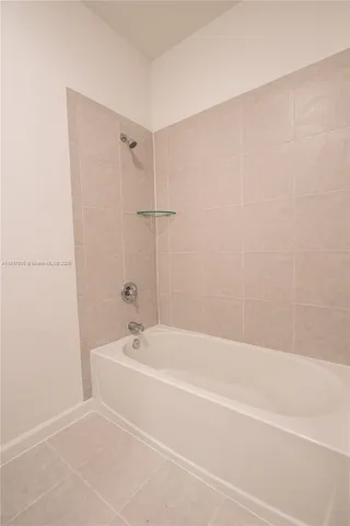 a white bath tub sitting next to a white sink and vanity