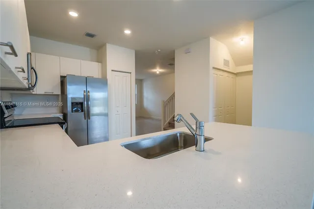 a kitchen with stainless steel appliances a refrigerator and a sink