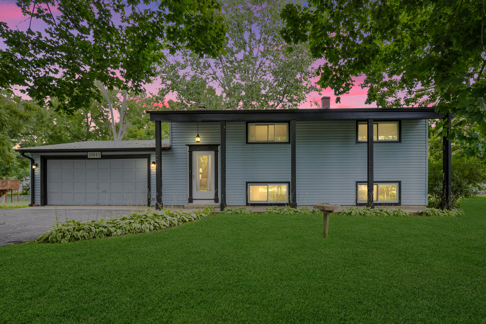 a front view of a house with a garden