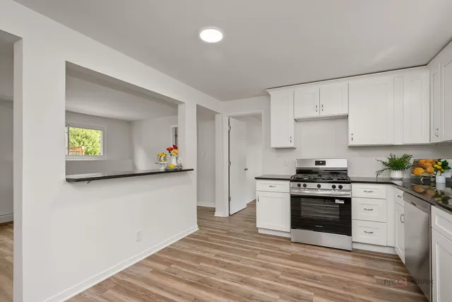a kitchen with stainless steel appliances granite countertop a stove and a refrigerator