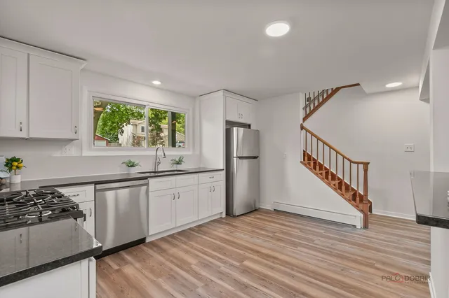 a kitchen with granite countertop a sink and a stove top oven