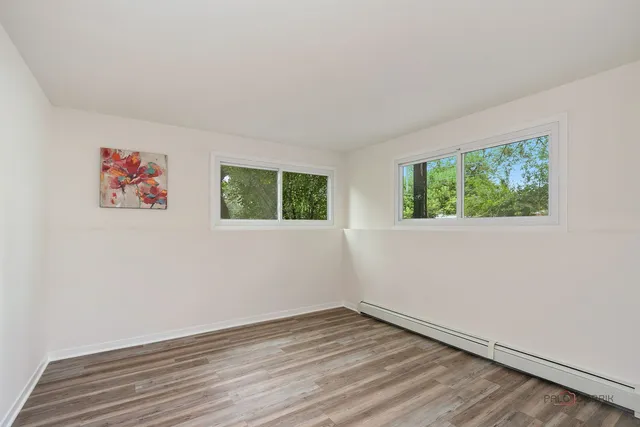 an empty room with wooden floor and window