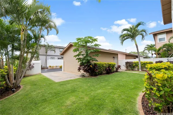 a front view of a house with a yard and potted plants
