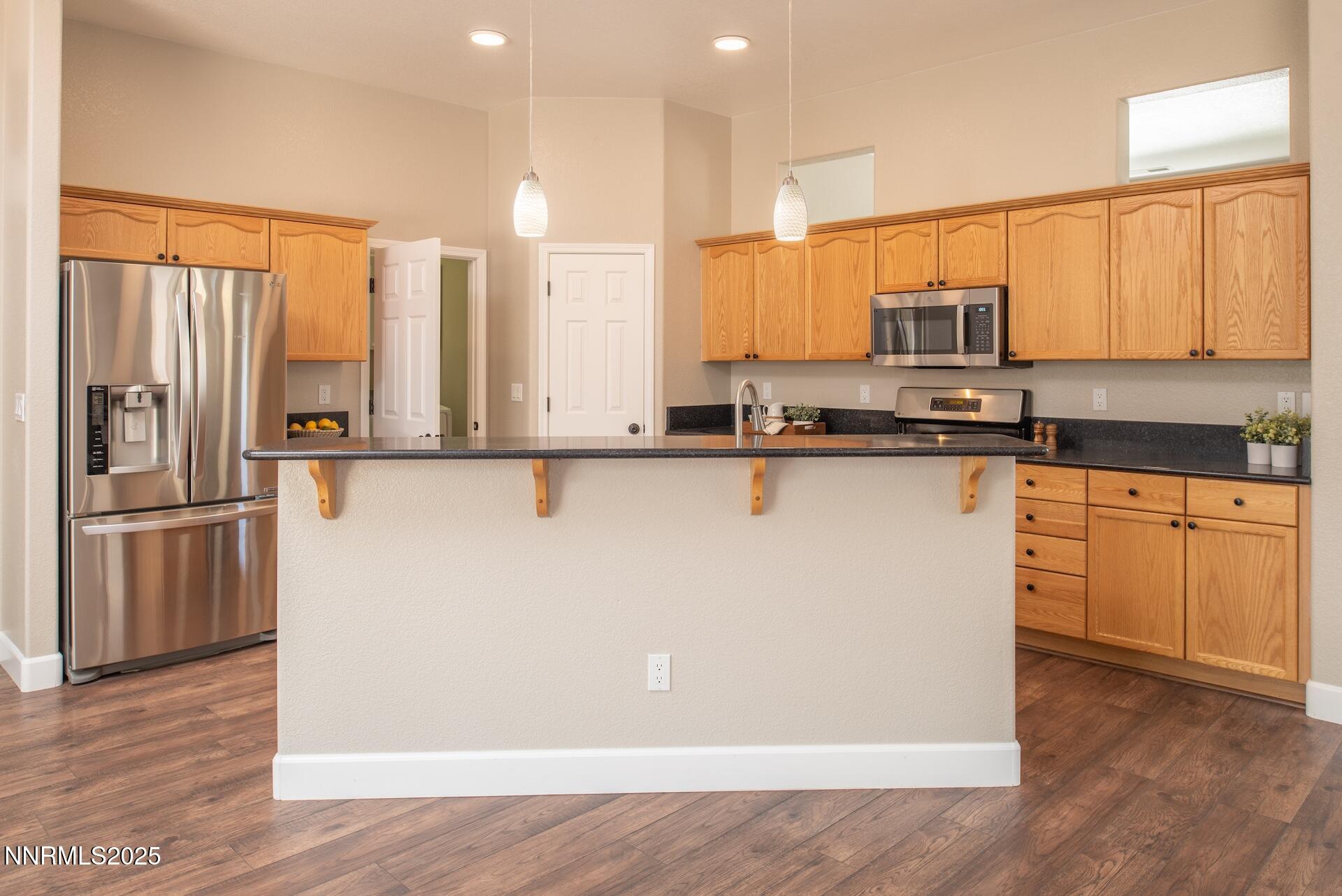 9579 Mammoth Court Reno, NV 89521 - Photo 12 of 39 a kitchen with stainless steel appliances a sink cabinets and wooden floor